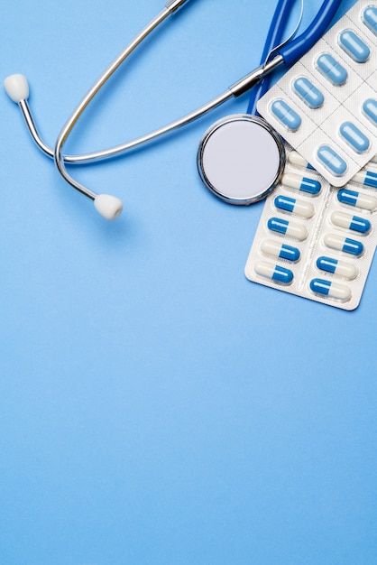 Premium Photo | Blister of pills capsiles and stethoscope isolated on blue background
