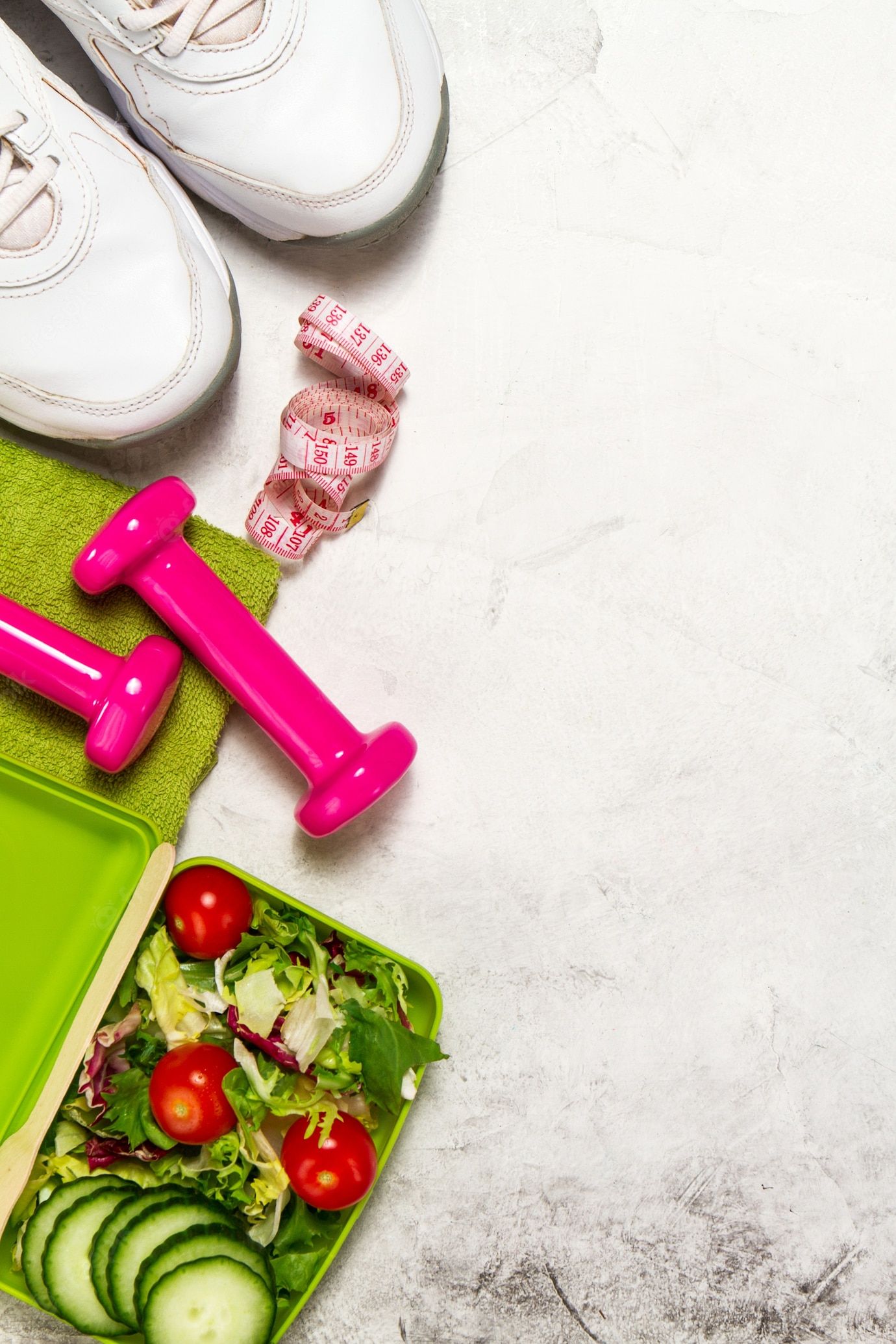 Premium Photo | Pink weights with a green towel and a tape measure